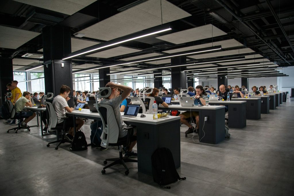 Big office with lots of employees working on laptops at their desks.