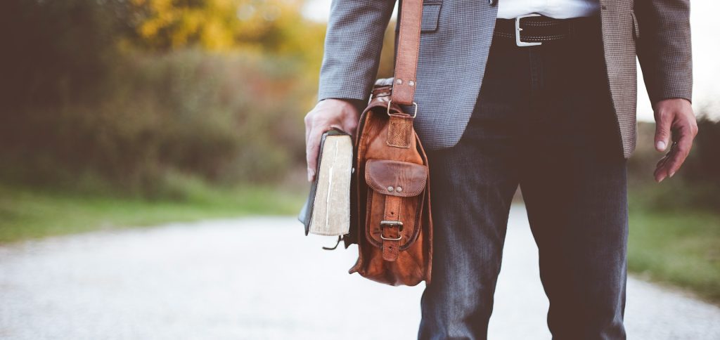 Man with leather bag and book